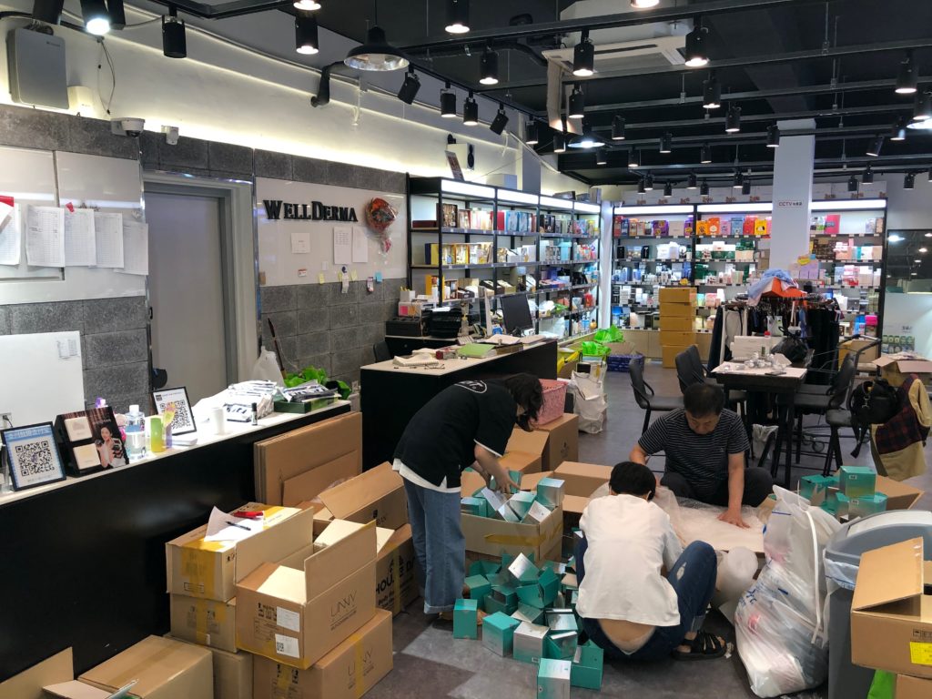 聚美化粧品店内の様子。従業員がダンボールが荷解きをしている。
